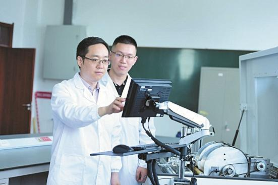     张若宇（前）在指导石河子大学研究生检测棉花品质（资料图片）。 石河子大学  提供