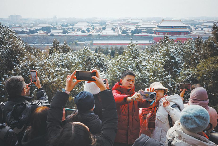 1月18日，景山公园，游客们拍摄故宫雪景。新京报记者 尹亚飞 摄