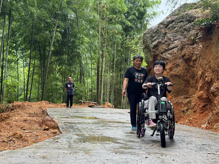 陈春花坐着轮椅行驶在“爱心路”回家。（受访者供图）