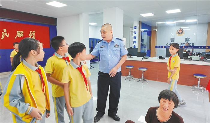 滨江派出所民警向等待家长的孩子们进行安全教育。海报集团全媒体中心记者 连蒙 摄