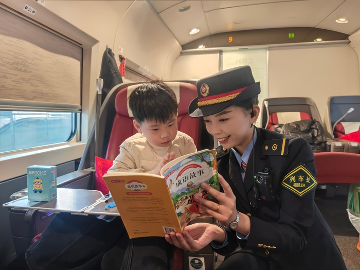 列车长帮助旅客临时照看儿童。许宵 摄