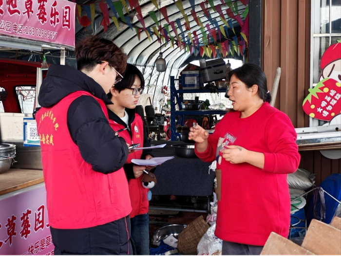 图为 团队对草莓基地的负责人进行采访