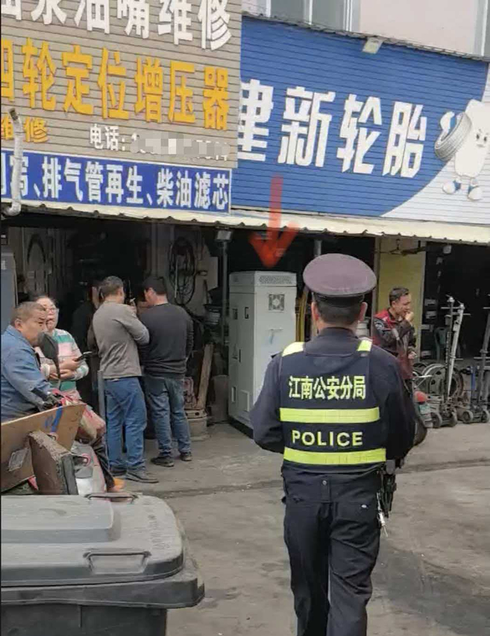 箭头处为配电柜，汽修店老板要800元保管费，民警前来协调（受访者贾师傅供图）