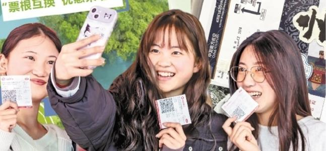 游客手持票根在电影海报前留影。范晖 摄 （影像贵州）