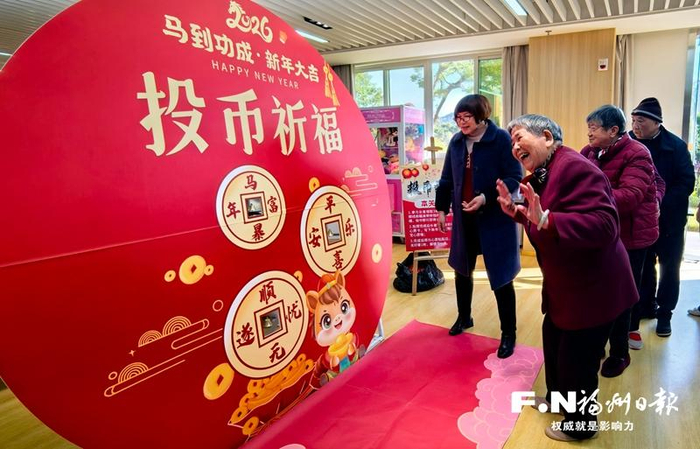 日前，在市社会福利院元旦主题活动中，老人刘小兰（左二）投中祈福铃。记者 潘温祥 摄
