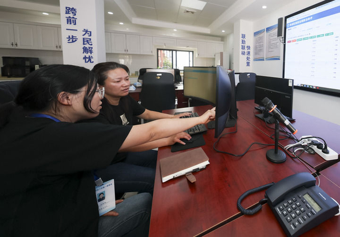 2025年5月12日，在上海市杨浦区殷行街道第五综合网格工作站，工作人员讨论通过“一键呼叫”与居民沟通。新华社记者 王翔 摄