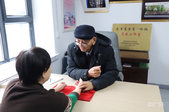 毛里夏里甫·哈帕正在为李女士把脉  （央广网记者  郭璁悦  摄）