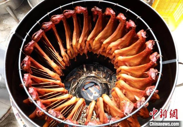 资料图：图为民众在熏制腊味。龚普康 摄