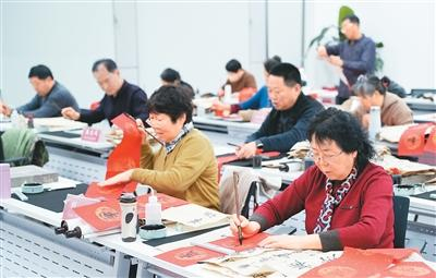 北京市朝阳区老年教育培训机构千尺学堂的书法教室，学员正在学写春联。受访企业供图
