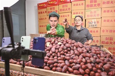 ▲ 在新疆和田地区墨玉县，新疆自由落体网络科技有限公司的主播在直播带货。新华社记者 丁磊/摄