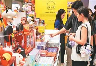图为2025年5月19日，顾客在泰国曼谷尚泰世界购物中心的泡泡玛特门店选购商品。新华社记者 孙玮彤摄