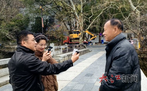 本报记者采访救人者之一、商户汪德冠（右）。