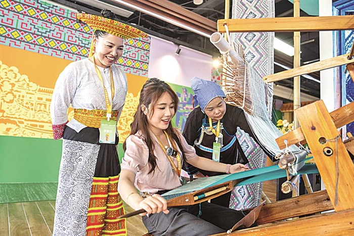 在湖南怀化市五溪非遗园，游客在体验侗族织锦技艺。新华社发