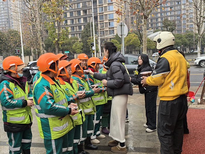 ▲社区工作人员为户外工作者送上腊八粥。