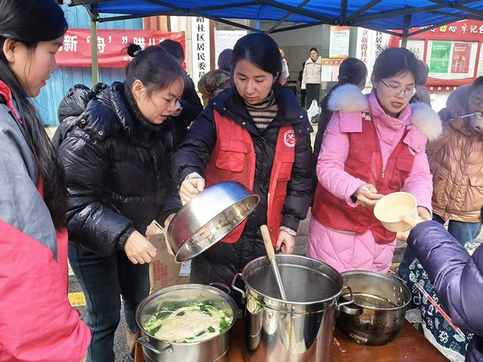 ▲立新路社区的工作人员正在煮腊八粥和长寿面。