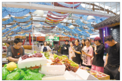 　游客在大观篆新农贸市场挑选水果。　　记者刘凯达摄