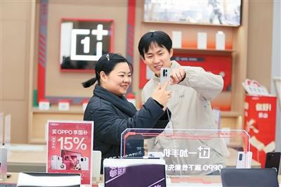 消费者在四川省乐山市市中区一家品牌销售店内选购手机。李华时摄（人民视觉）