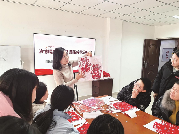 向青少年传授剪纸技法。