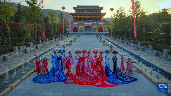 模特身穿剪纸服饰在甘肃省镇原县北石窟驿景区内进行展示。新华社发