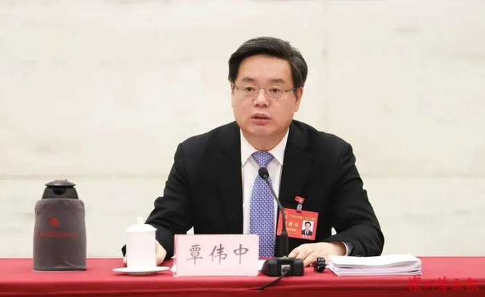 开放团组活动上，覃伟中回答记者提问。