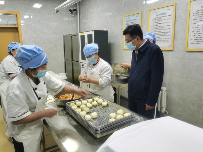 兰州新区纪检监察工委工作人员聚焦中小学校园食品安全开展监督检查，现场了解学生餐食保障情况。