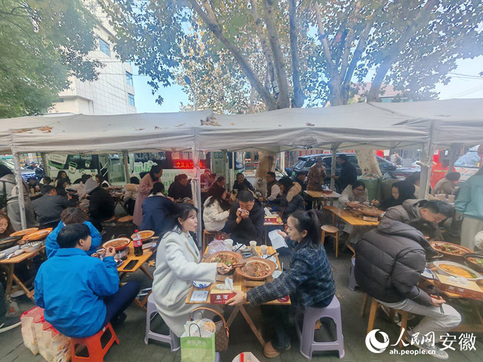 在迎春街，游客们品尝广德炖锅。人民网记者 王锐摄