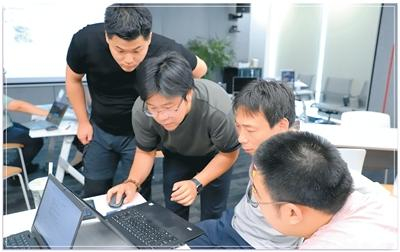 佘汀涛（左一）和蒋越（左二）在与客户讨论产品需求。受访者供图