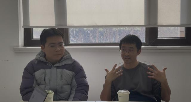 学者董辉（右）讲述论文创作过程。 王倩 摄