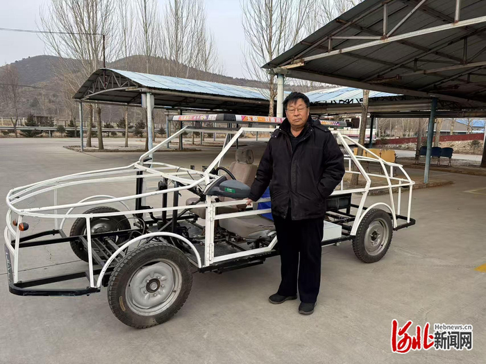 图为梁启与骨架车合影。梁启供图