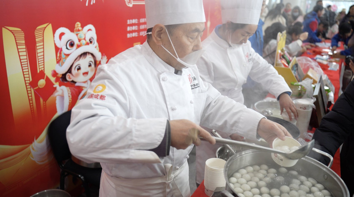 成都东站汽车客运站春运服务点送汤圆。