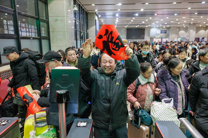 2月1日23时许，北京西站，旅客高举刚刚收到的福字。新京报记者 王子诚 摄