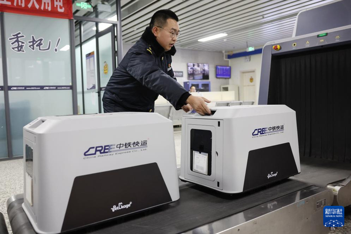 2月1日，中铁快运兰州西站营业部工作人员孙谦将旅客托运的宠物放在安检仪上准备进行安检。新华社记者 陈斌 摄