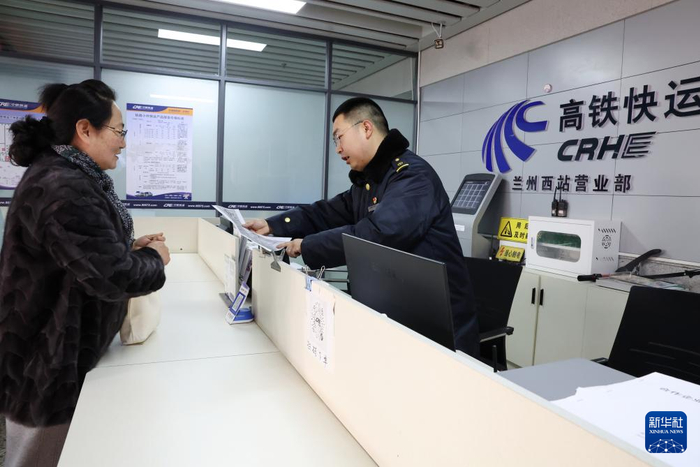 2月1日，中铁快运兰州西站营业部工作人员孙谦（右）为旅客董文琦办理宠物托运手续。新华社记者 陈斌 摄