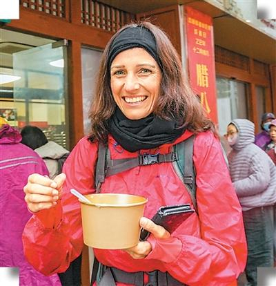 图为近日，在上海静安寺，外国游客品尝中国美食腊八粥。