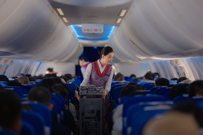 南航乘務員在航班上為旅客分發(fā)餐食。