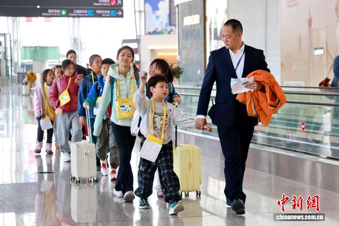 2026年春运启幕，各大航空公司加大服务保障力度。图为南航工作人员引导无人陪伴儿童登机。南方航空 供图