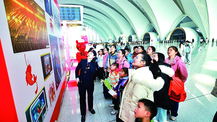 ▲南昌东站的春运摄影作品展吸引旅客驻足。 张杰 图