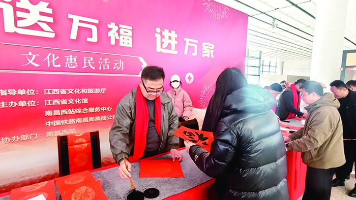 ▲南昌西站的书法名家送福活动上，书法名家现场为旅客写福字。 曹凡圣 图