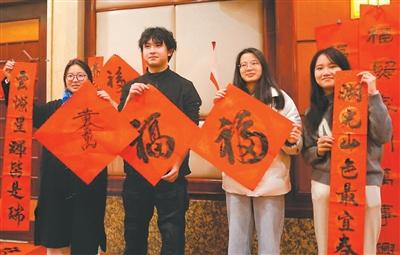 图为在福州举办的台胞迎新春联谊活动中，台胞展示书写的“福”字和春联。