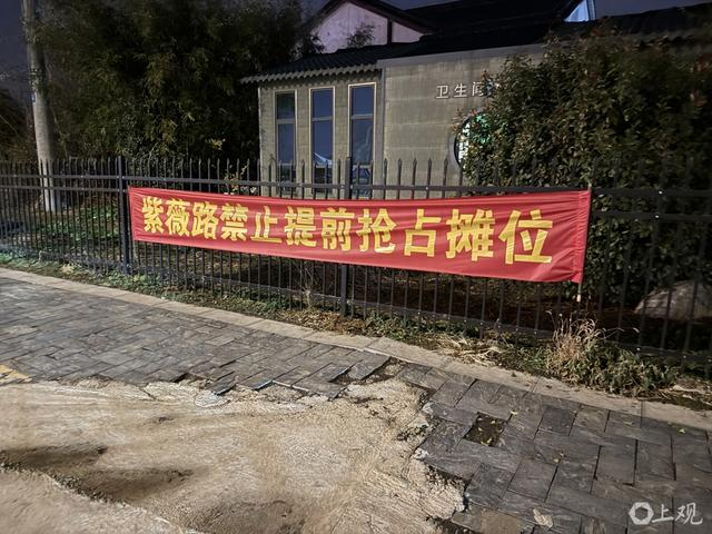 “紫薇路禁止提前抢占摊位”横幅。巩持平摄