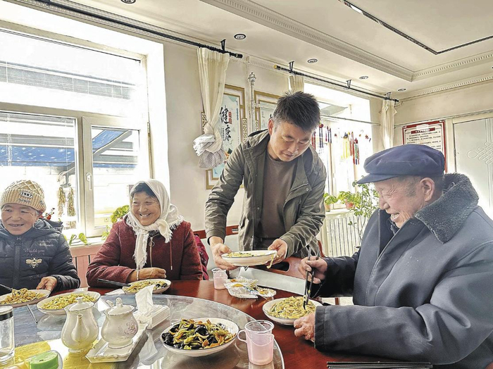 一有空闲，村党支部书记王进寿就来食堂帮忙。杨燕玲 摄