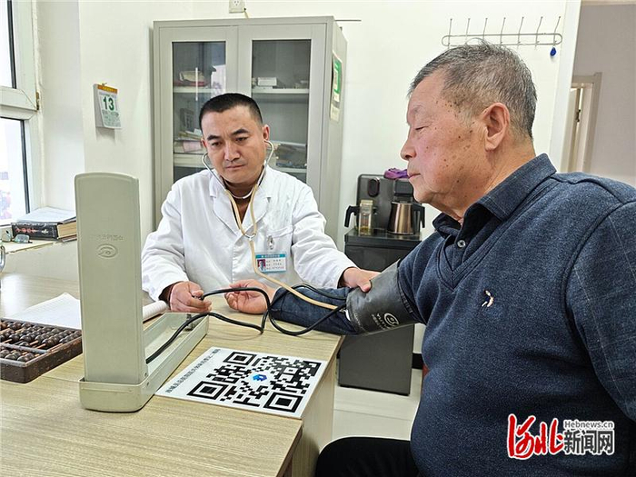 1月13日，在故城县五户村卫生室，医生为老人量血压。河北日报记者 魏 雨摄