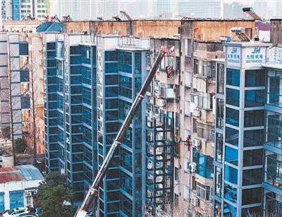 近年来，湖北襄阳将老旧小区加装电梯作为重要民生实事扎实推进，助力城市更新。图为工人在一小区为旧楼加装电梯。