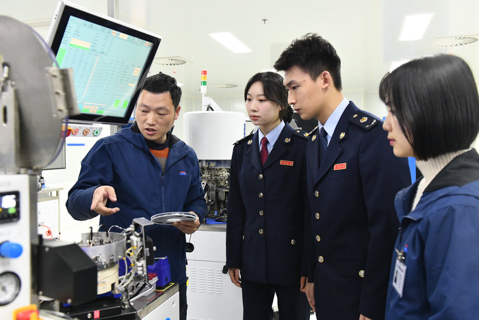 四川明德亨电子科技有限公司工作人员向税务人员介绍芯片生产情况 四川省税务局供图