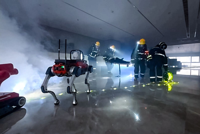 在河南省超高层建筑灭火应急救援综合实战演练中，消防人员与机器狗协同作战。