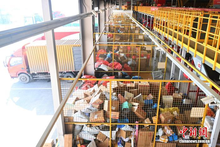 2月初，兰州市一快递物流转运中心内，工作人员进行分拣装车工作。　李亚龙 摄