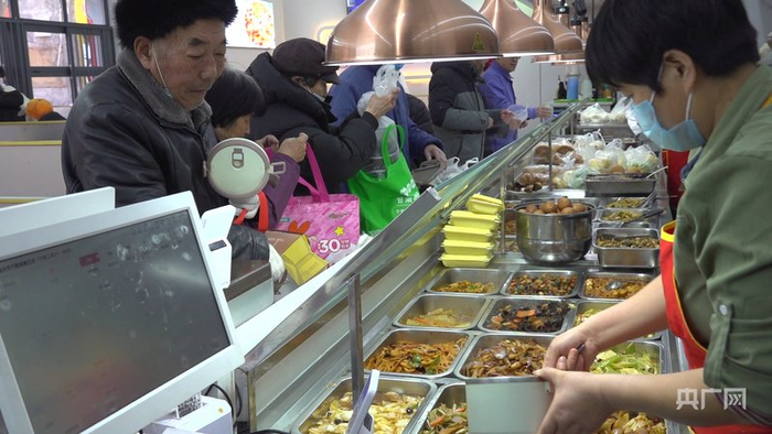 老人们在助餐点排队打饭（央广网记者  寇刚  摄）