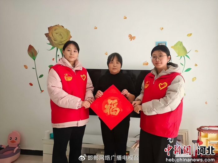 图为青年志愿者为社区老人送福字。　孙利克 摄
