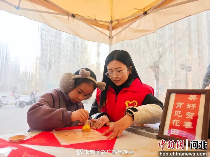 图为青年志愿者正在辅导小朋友体验传统拓印技艺。 孙利克 摄