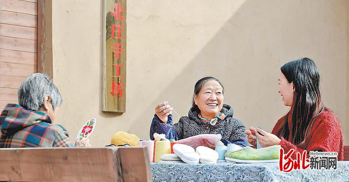 2月4日上午，团结北庄手工坊门前，关凤霞（中）和王亚梅（右）边赶工边聊天。  河北日报记者 赵海江摄